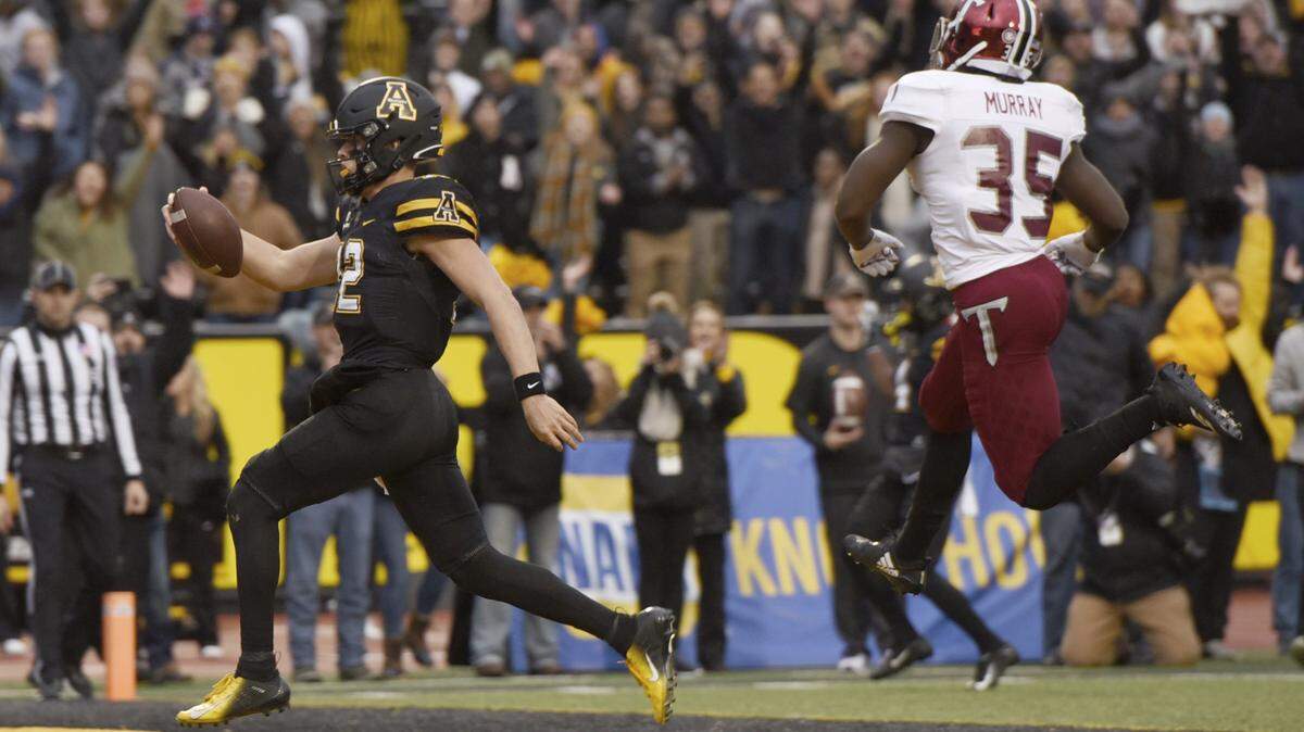 Appalachian State quarterback Zac Thomas (left) scores against Troy in the Mountaineers’ victory on Nov. 24.