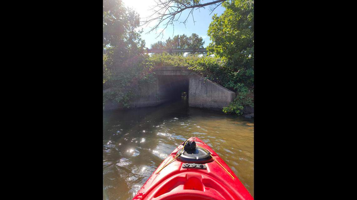 Kayaker Wyatt Maxey approaches the tunnel-like culvert beneath Interstate 77 that connects Lake Cornelius with Lake Norman.