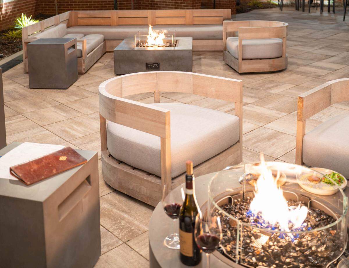 Golden Owl Tavern has outdoor fire pits and heat lamps on its wraparound patio facing the LNYX Blue Line University City Station.