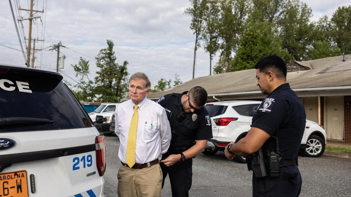 Business owner, Paul Bradley, is detained by law enforcement for blocking the door from a locksmith on his commercial property in Charlotte, N.C., on Wednesday, September 20, 2023. Paul Bradley is in a dispute with code enforcement over him allowing homeless people to camp on his commercial property