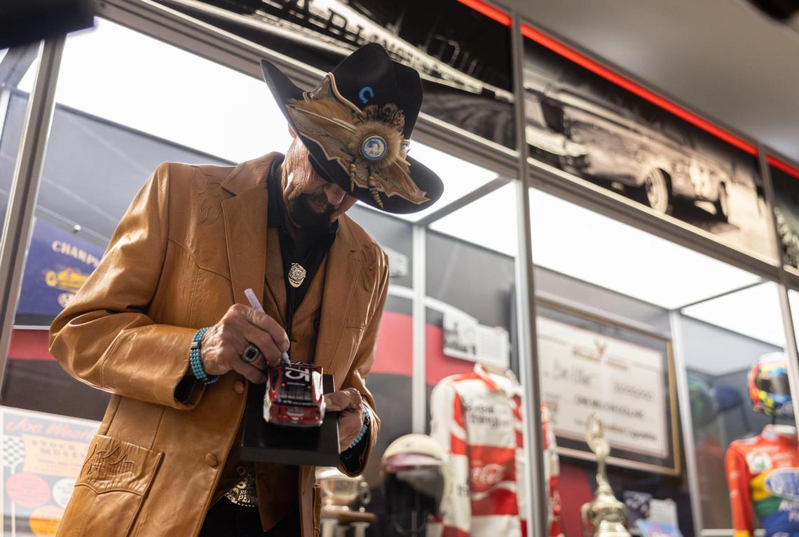 NASCAR Hall of Famer Richard Petty signs a model car at the Darlington Raceway 75th Anniversary Exhibit at the NASCAR Hall of Fame Charlotte. The venue is a major draw for the Charlotte region, according to the Charlotte Regional Visitors Authority. 