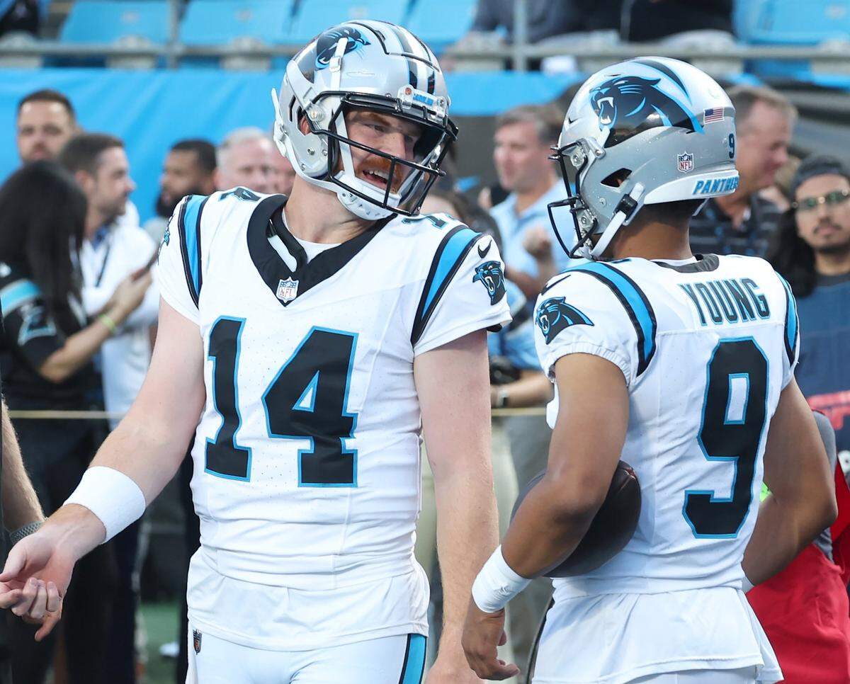 Carolina Panthers quarterback Andy Dalton, left, speaks with quarterback Bryce Young during a pregame workout at Bank of America Stadium on Monday, September 18, 2023.