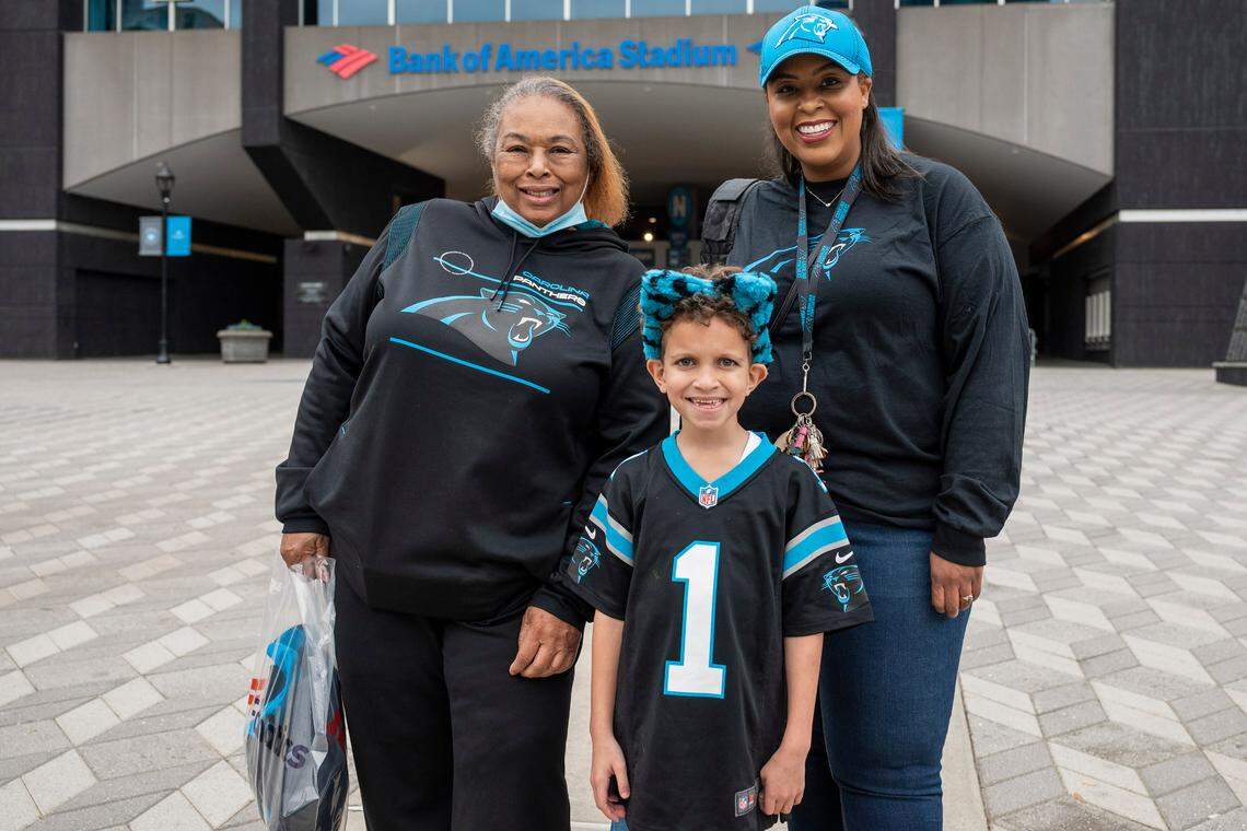 From left, Gladys, Devlin and Isaiah Adams pose for a photo outside of Bank of America Stadium on Thursday, November 11, 2021 in Charlotte, NC. The Adams family, from Gastonia, were excited about the news of former quarterback, Cam Newton, being signed for a one-year contract to return to the Panthers. They came to the stadium to pick up their season tickets and view their seats. About what she is looking forward to the most about Newton’s return, Devlin said, “The excitement; the whole energy he gives.”