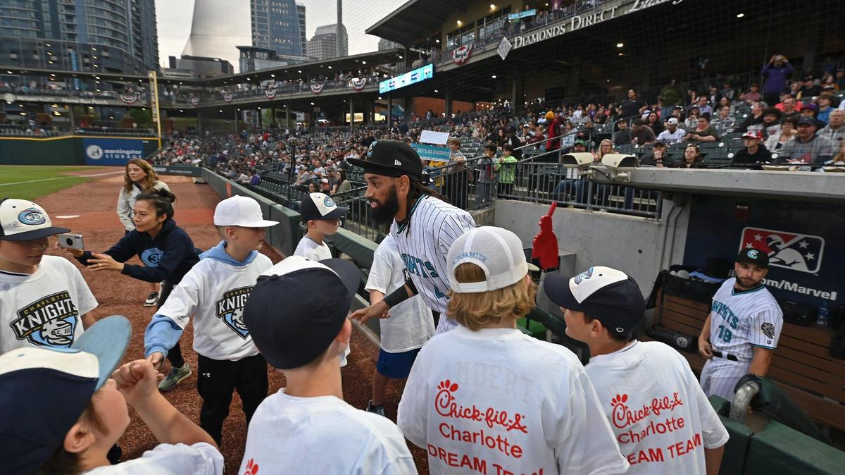 Charlotte Knights centerfielder Billy Hamilton, center, slaps hands as he exits the dugout prior to action against the Memphis Redbirds at Truist Field in Charlotte, NC on Friday, March 31, 2023.