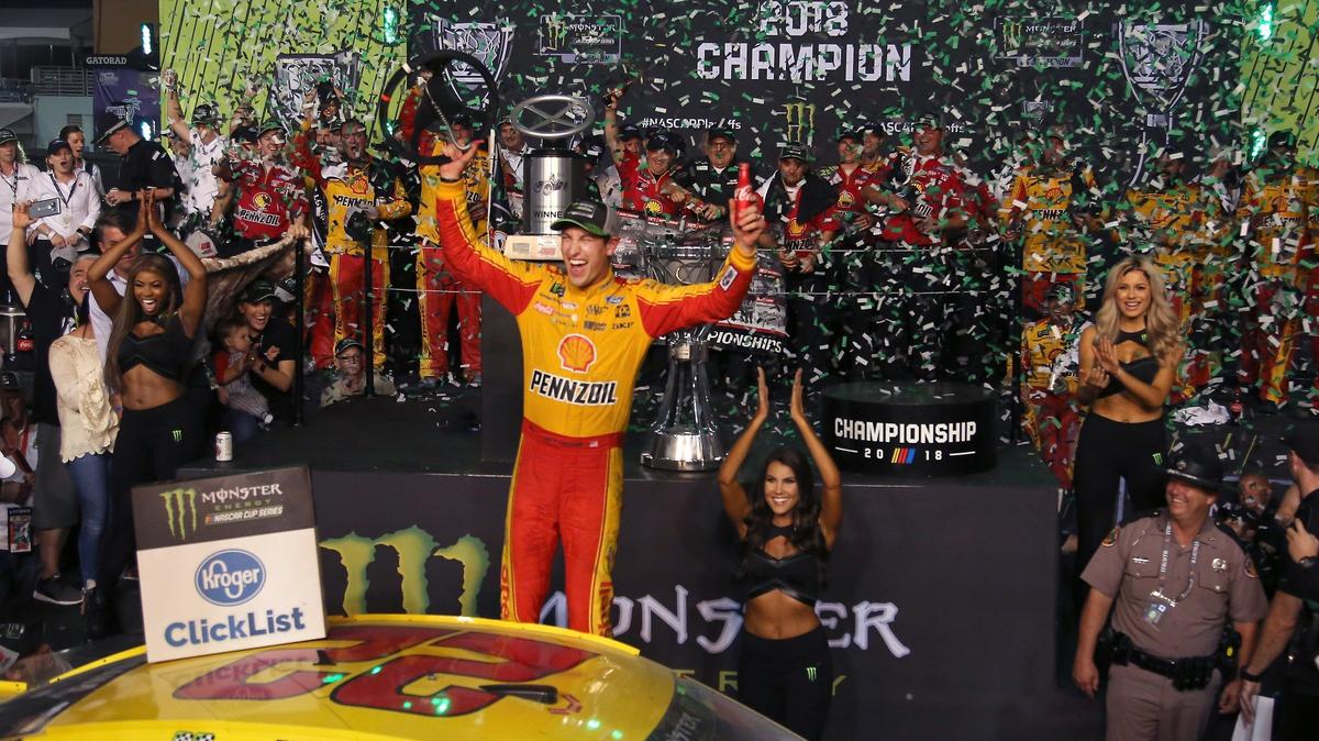 Joey Logano poses next to his car in Victory Lane after a late-race pass of Martin Truex Jr. allowed him to drive away with the 2018 NASCAR Cup Series championship at Homestead-Miami Speedway.