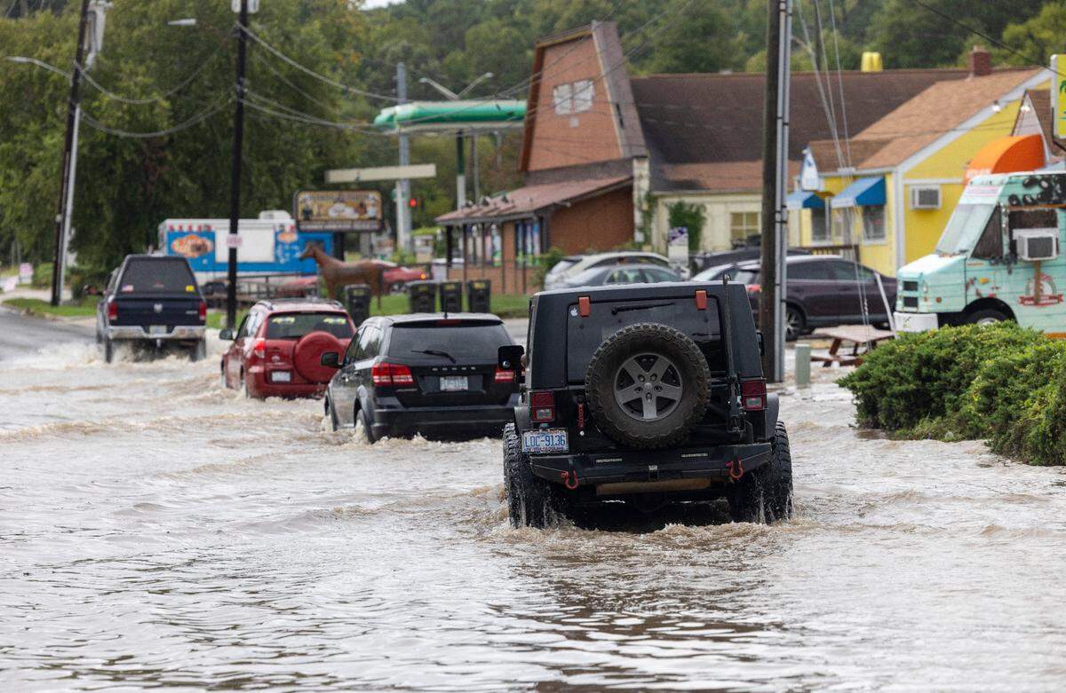 Motorist traverse flooded Foushee Street after heavy rain from Tropical Storm Helene flooded the area adjacent to Ellerbe Creek on Friday, September 27, 2024 in Durham, N.C.