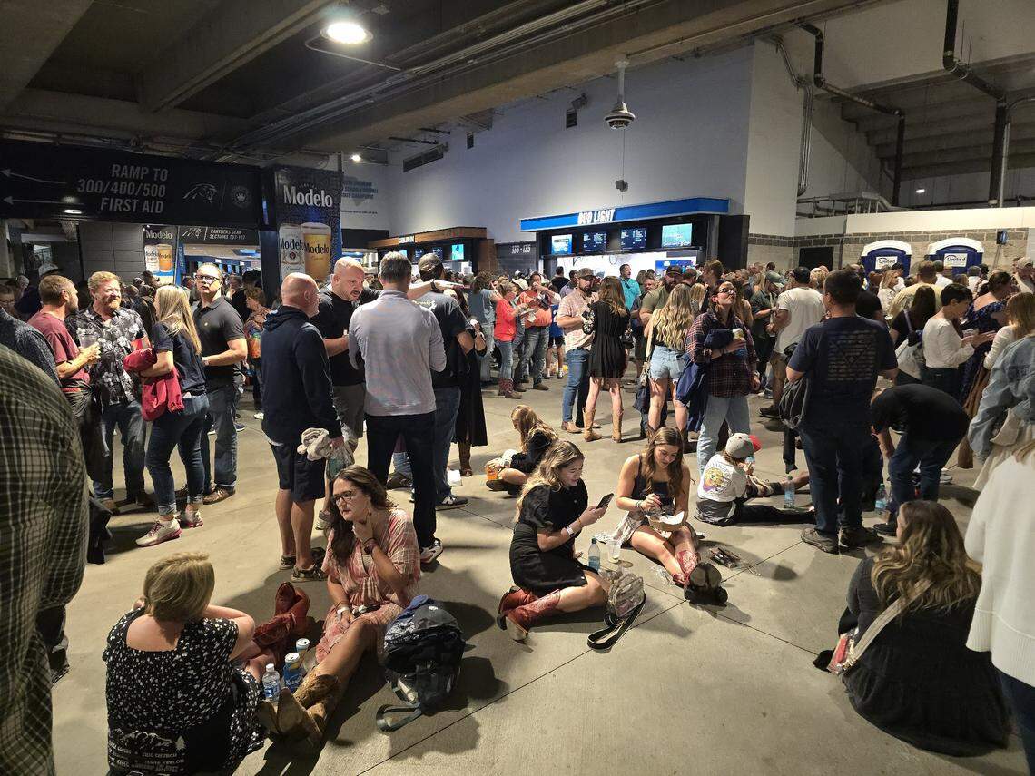 Attendees for Concert for Carolina wait in the concourse of Bank of America Stadium as inclement weather was cause for an evacuation until conditions clear in Charlotte, NC on October 26, 2024.