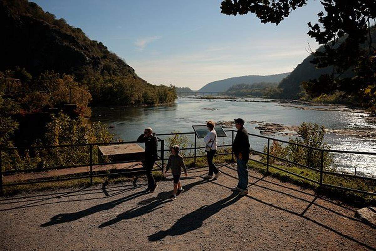 HARPERS FERRY, WV - OCTOBER 02: Visitors look at the confluence of the Potomac and Shenandoah rivers in the Harpers Ferry National Historical Park Lower Town on October 02, 2025 in Harpers Ferry, West Virginia. While monuments, trails and other outdoor exhibits remained accessible to visitors, many buildings were locked and National Park Service employees were told to stay home during the ongoing federal government shutdown. (Photo by Chip Somodevilla/Getty Images)