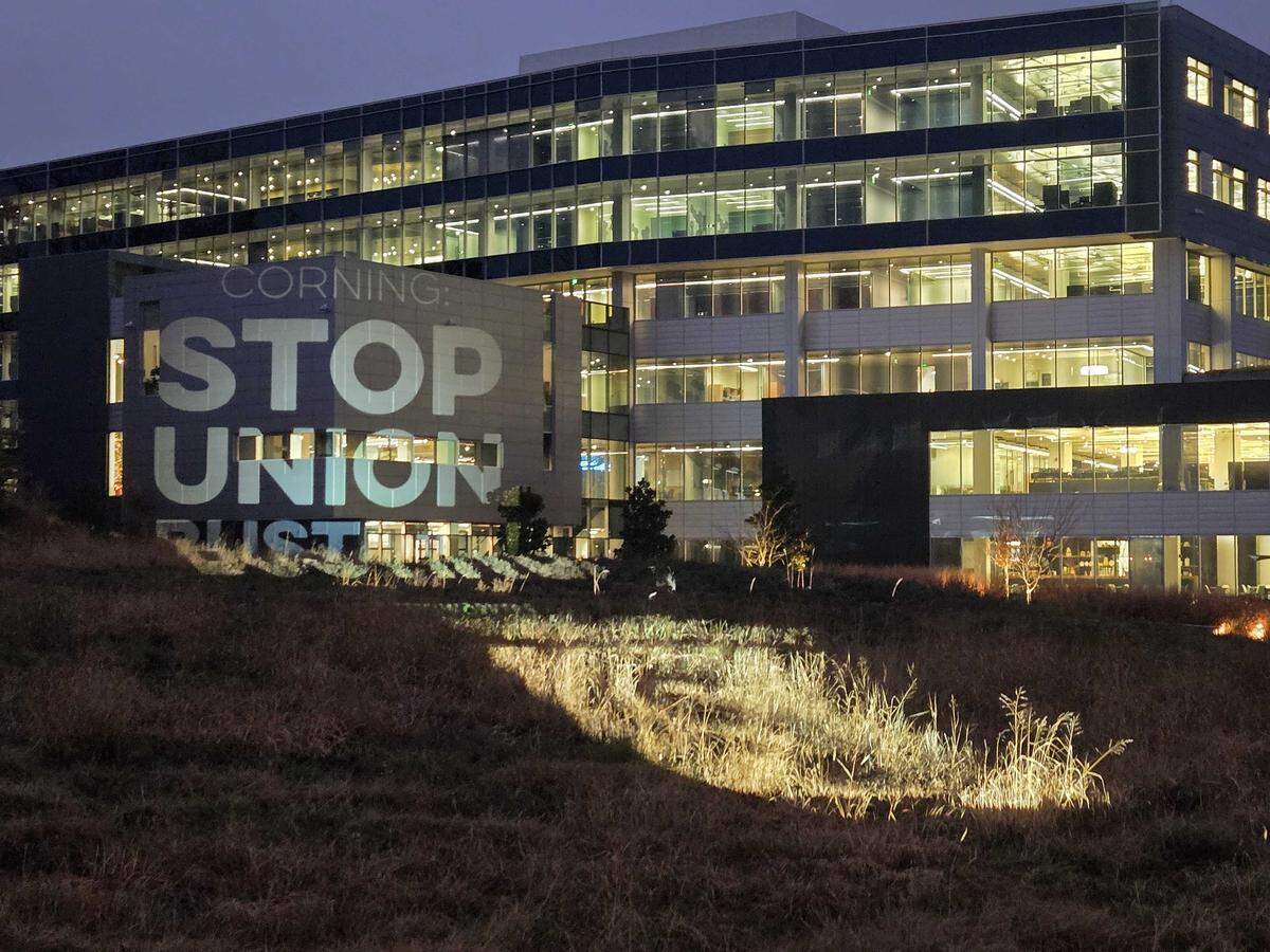 United Steelworkers shined a projected light with a message “Stop Union Busting” to Corning at its Charlotte headquarters on Monday.