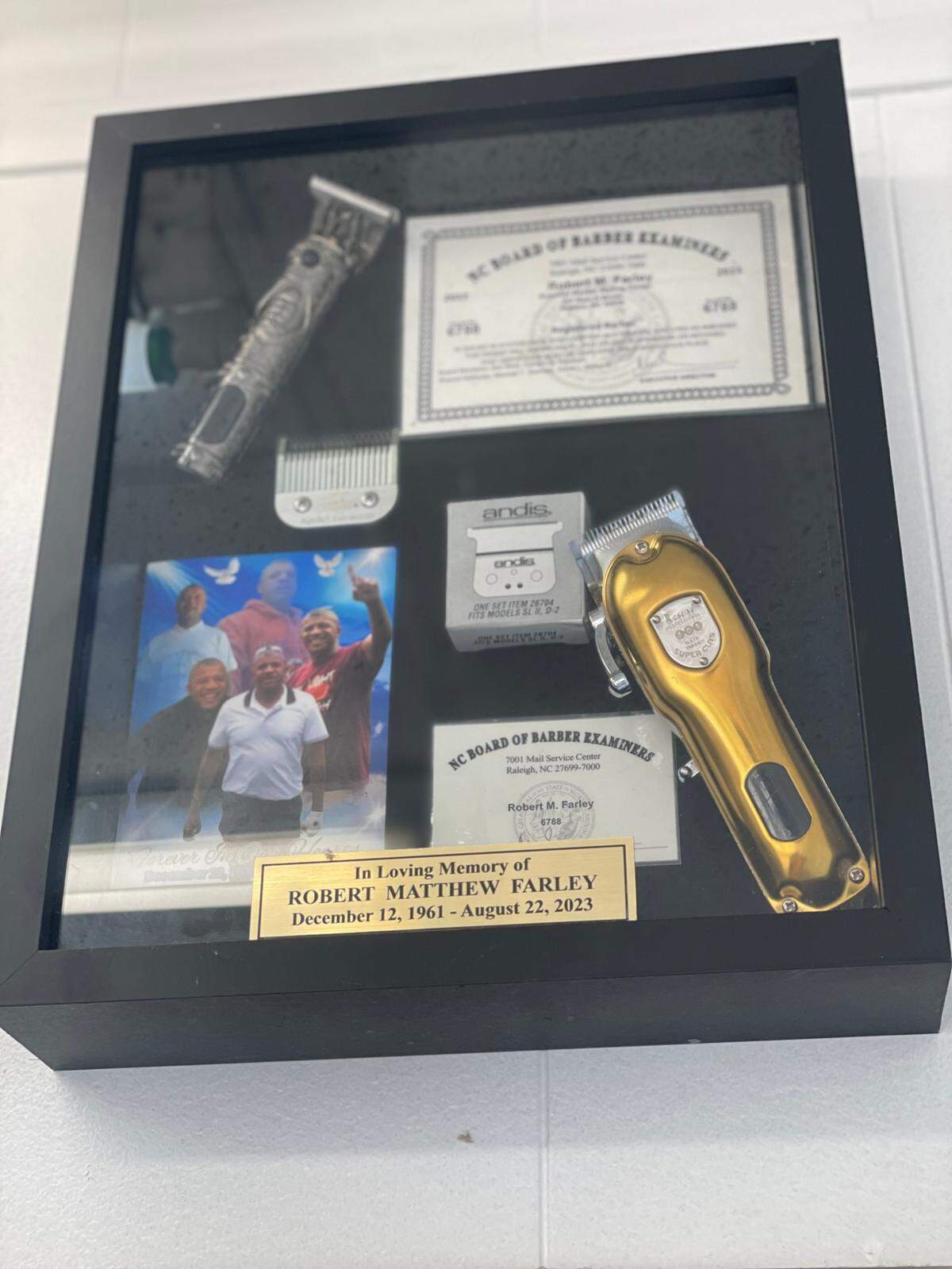 A frame hanging on a wall in the Superior Cuts Barbershop in Newton, N.C., honoring the life of Robert Farley, who ran this place with his brother, Elijah, before Robert’s tragic death in August 2023.