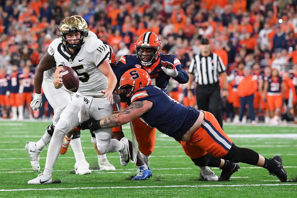 Nov 25, 2023; Syracuse, New York, USA; Syracuse Orange defensive lineman Kevon Darton (right) sacks Wake Forest Demon Deacons quarterback Michael Kern (15) during the second half at the JMA Wireless Dome. Mandatory Credit: Rich Barnes-USA TODAY Sports