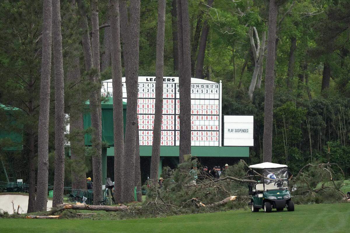 Volunteers and staff secure the area around where a tree fell near the 17th tee during the second round of The Masters golf tournament. 