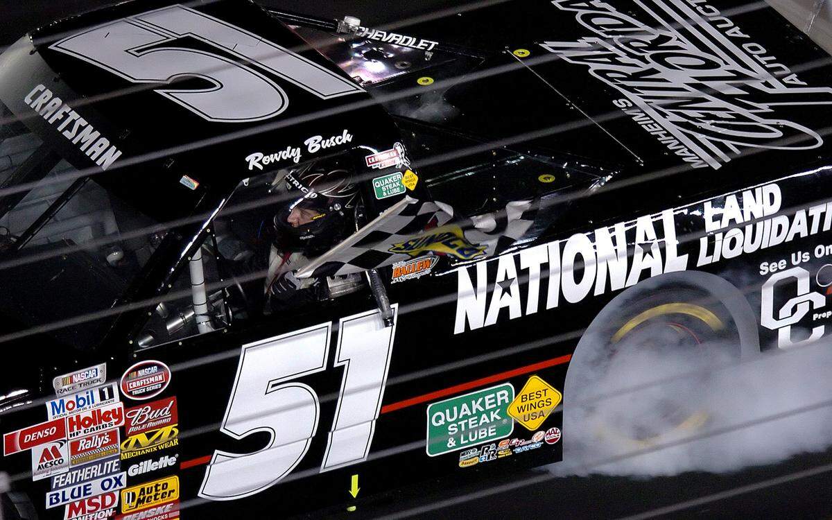 5/19/06 NASCAR NEXTEL Cup driver Kyle Busch carries the checkered flag while doing a burnout down the frontstretch of Lowe's Motor Speedway Friday following his victory in the Quaker Steak & Lube 200 truck race Friday at Lowe's Motor Speedway.  JEFF SINER - jsiner@charlotteobserver.com