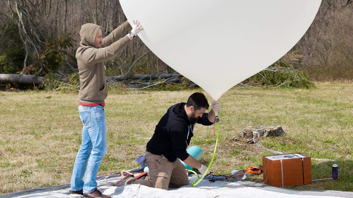 Brian Wallace, co-founder of Devil’s Logic, fills the weather balloon with helium while Adam Henley assists.