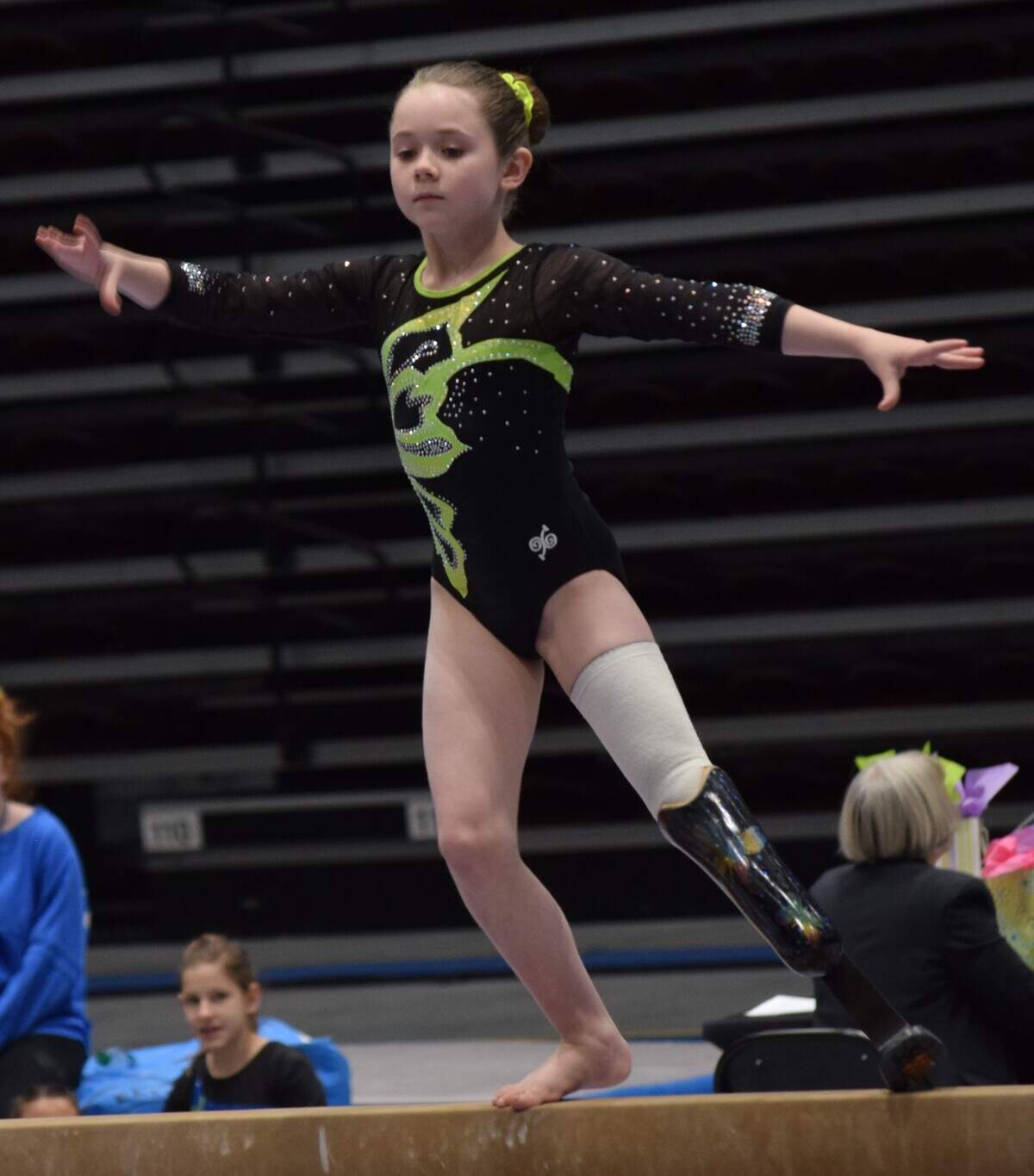 Zoe Smith, a 10-year-old gymnast from outside Asheville, performs on the balance beam. Zoe had her left foot amputated at age one and competes with a prosthetic left leg.