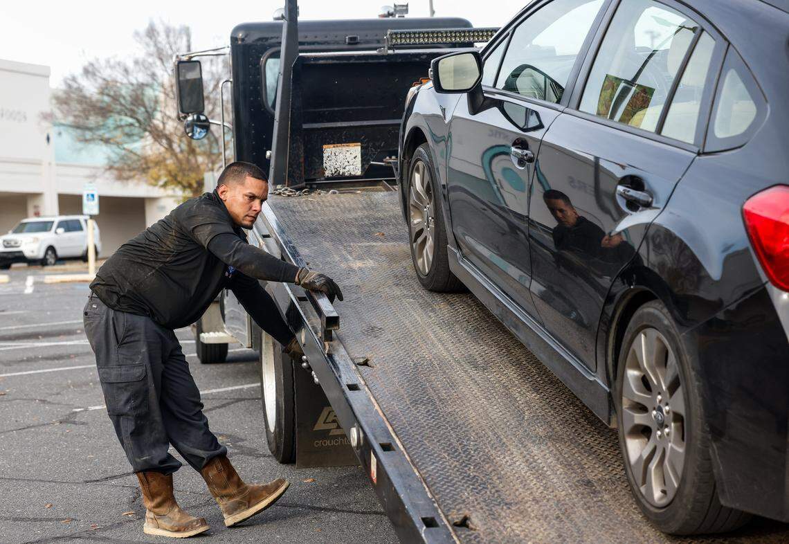 Ramon Vargas, who works with Carolina’s Towing, loads a vehicle that was left behind after its owner was arrested by Border Patrol at Eastway Crossing in Charlotte, NC on Tuesday, November 18, 2025. Carolina’s Towing is a Hispanic-wned business on Freedom Drive that is offering free towing service  to help families recover vehicles after a loved ones has been detained.