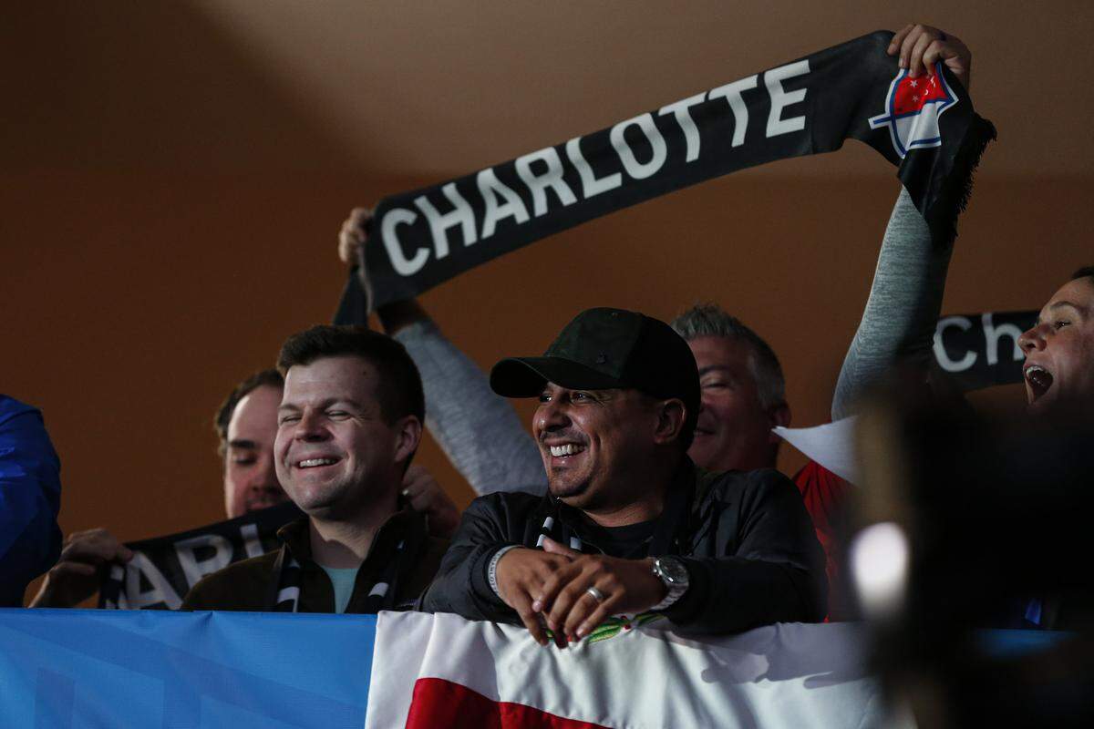 Soccer fans celebrate the announcement of a Major League Soccer team, owned by David Tepper, that will begin play Charlotte in 2021 at an event in Charlotte, N.C., Tuesday, Dec. 17, 2019. (AP Photo/Nell Redmond