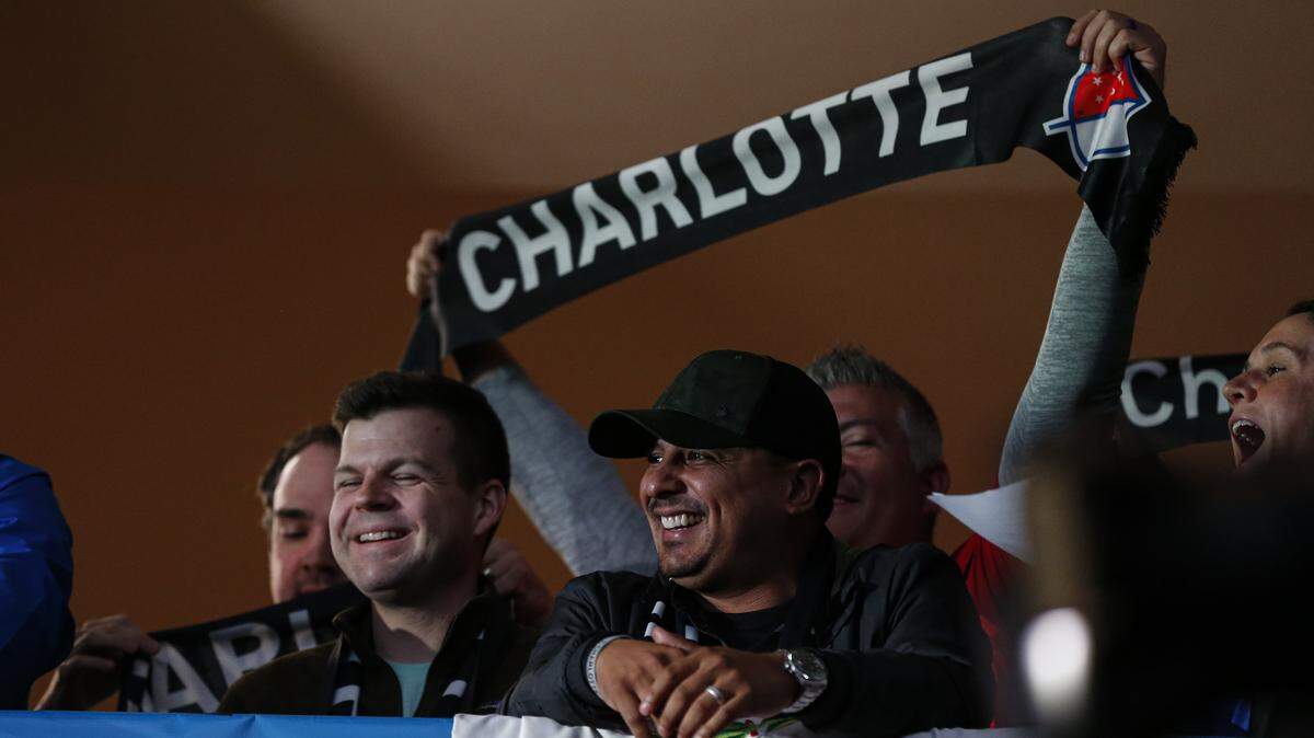 Soccer fans celebrate the announcement of a Major League Soccer team, owned by David Tepper, that will begin play Charlotte in 2021 at an event in Charlotte, N.C., Tuesday, Dec. 17, 2019. (AP Photo/Nell Redmond