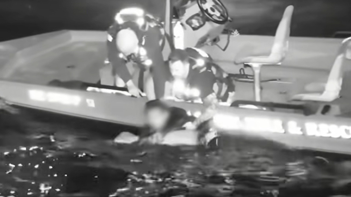 This video screengrab shows the moment two rescuers pulled the swimmer from the water and onto a boat. “Crews worked through darkness, wind, waves, and distance from shore to locate and rescue a male in the water,” officials said.