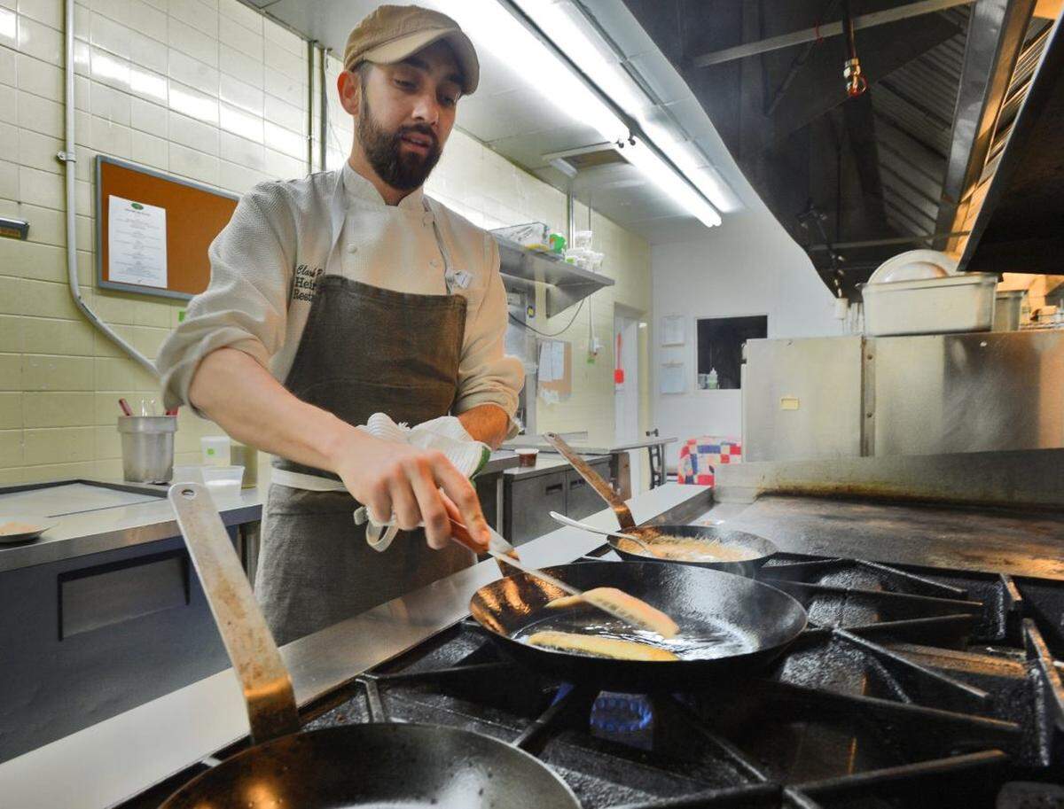 Chef Barlowe creates a fish and grits entree. Clark Barlowe, head chef of Heirloom Restaurant and native of Lenoir.
