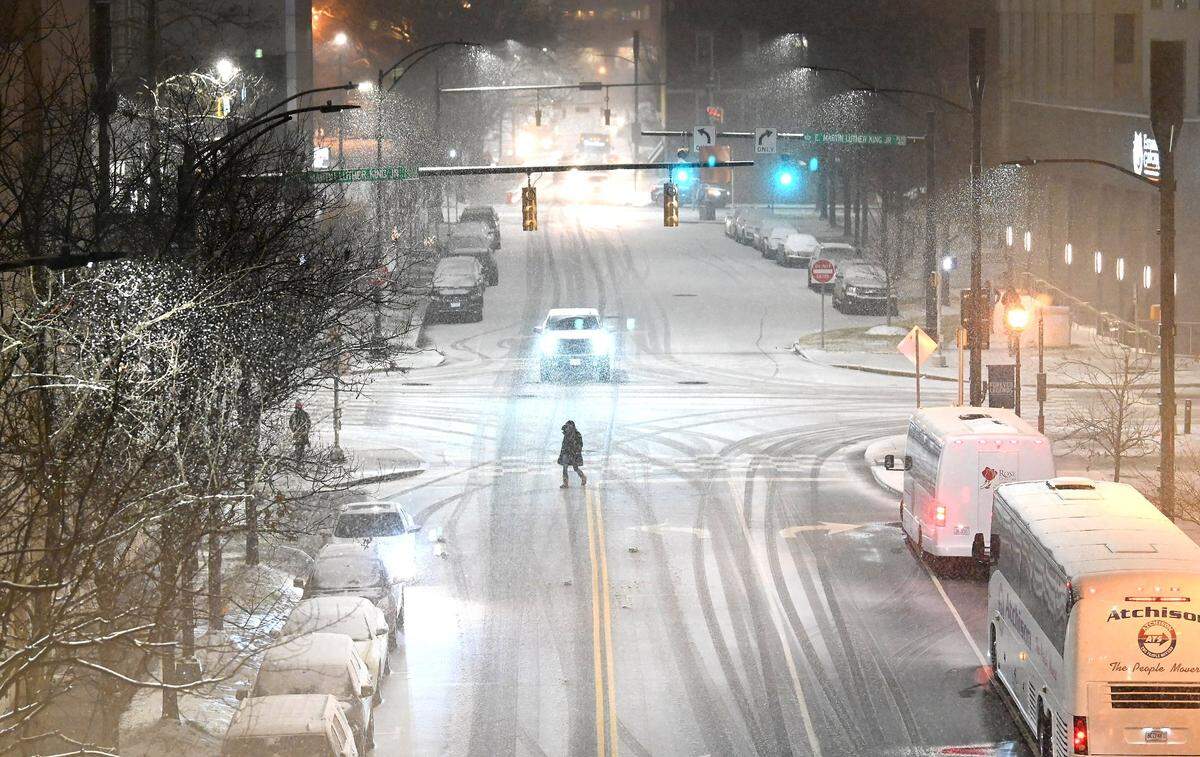 A pedestrian crosses Brevard Street as snow falls in uptown Charlotte in January 2022.