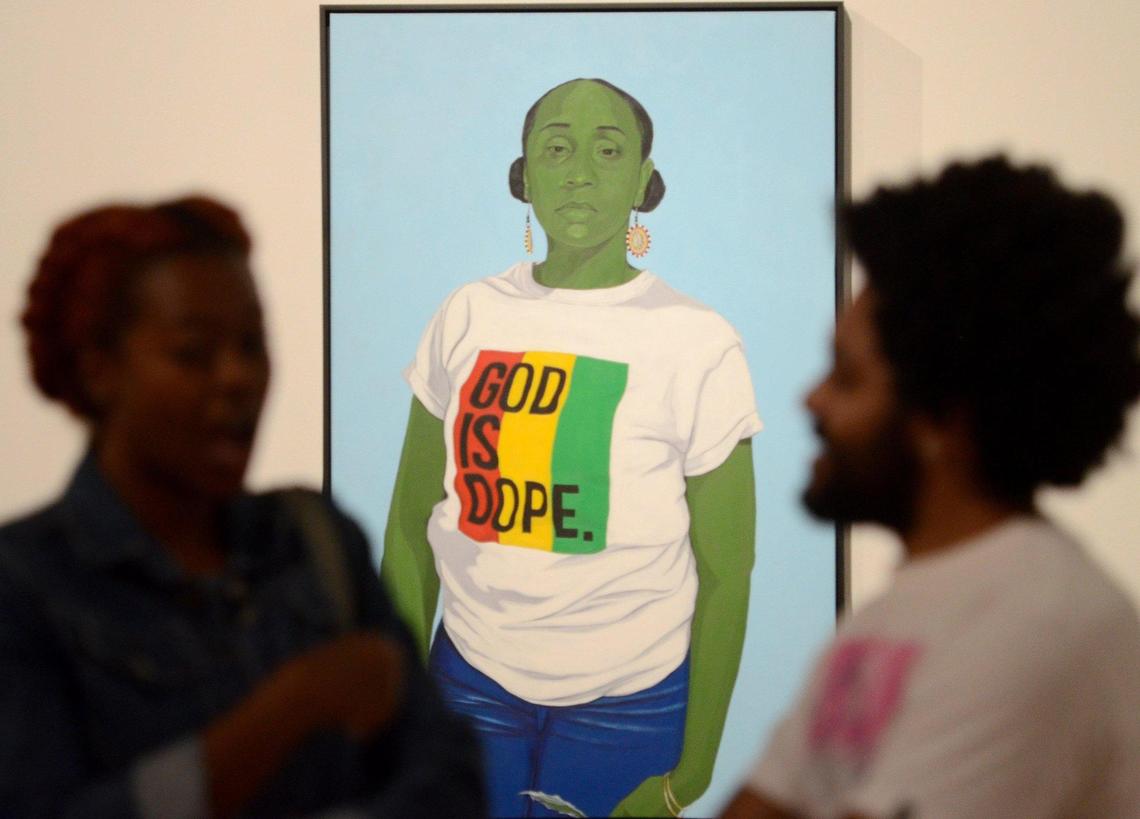 Clarence Heyward’s “God is Dope” is a portrait of a woman featuring a shirt from the iconic Atlanta brand of the same name. It’s one of the paintings at the Gantt Center’s second biennial, “my Presence is Present: interpretations of afrosurrealism from the American South.” The show runs through Jan. 15.