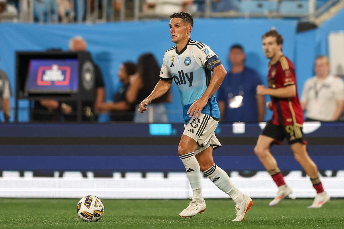 Charlotte FC midfielder Ashley Westwood (8) dribbles the ball against Atlanta United during the second half of a late August match at Bank of America Stadium.