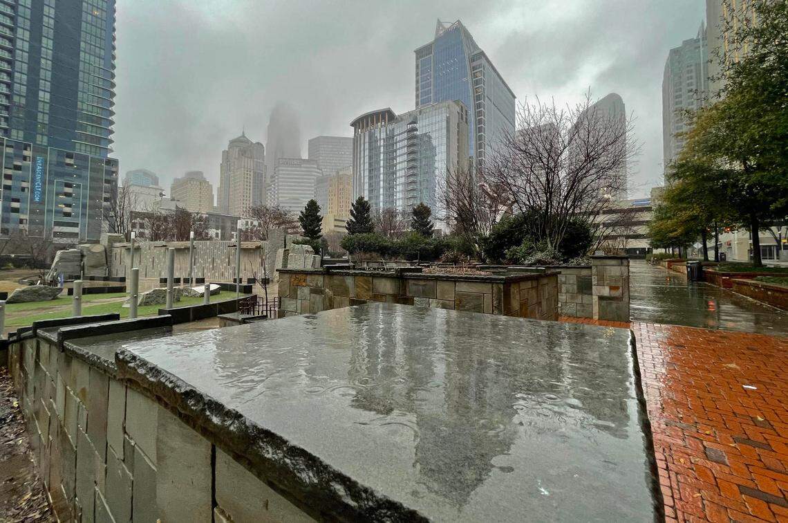 The uptown skyline is reflected in the rain soaked masonry at Romare Bearden Park on Thursday, February 18, 2021. The Charlotte metro area could see heavy rain and cooler temperatures with the arrival of fall, National Weather Service says.