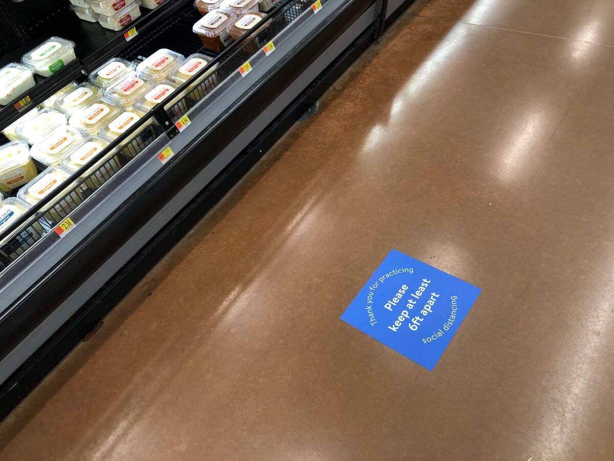 Signs on the floor warn Walmart shoppers to practice social distancing in Indian Trail on April 5.