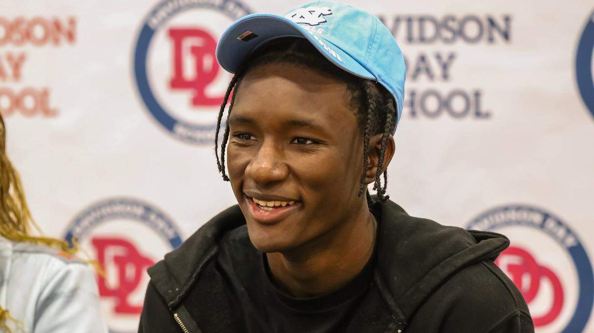 Isaiah Denis is all smiles for fans after announcing his choice to attend UNC to play basketball during his college commitment day event on Saturday at Davidson Day School.