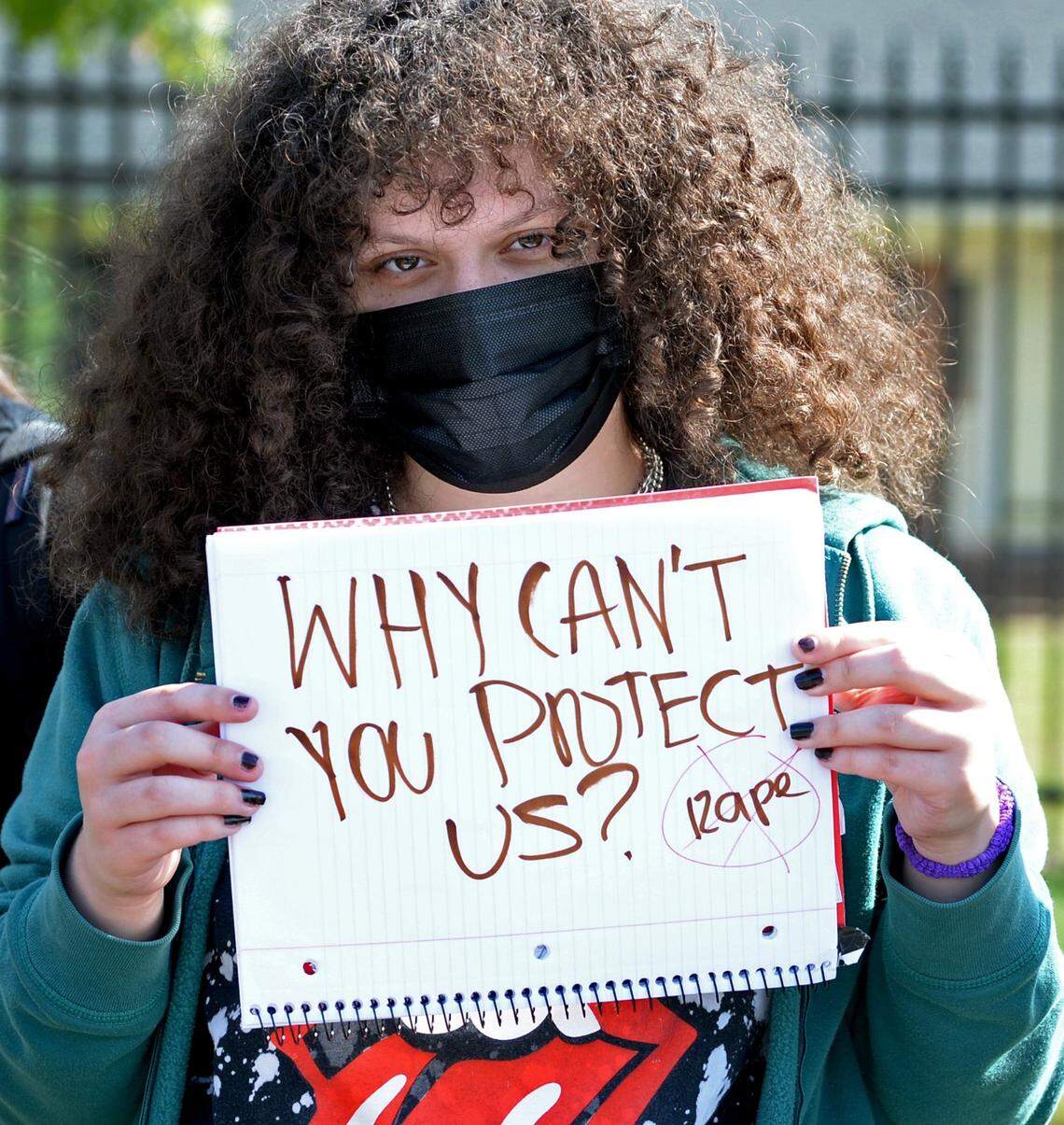 Olympic High student Caryna Cozaya holds a sign in protest outside the school on Friday, October 1, 2021 in Charlotte, NC. On Sept. 13, a 15-year-old student was charged with sexual assault of a female student. Another student, a football player, had been accused of assault and told to wear an ankle monitor. The athlete played in a recent football game wearing the monitor.