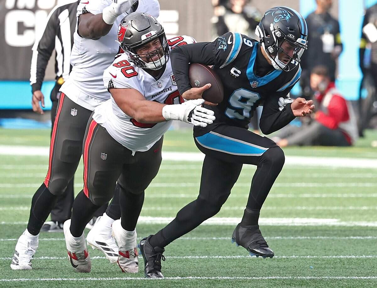 Carolina Panthers quarterback Bryce Young, right, rushes for yardage as Tampa Bay Buccaneers defensive lineman Logan Hall, left, looks to make the tackle during action on Sunday, Dec. 1, 2025, at Bank of America Stadium in Charlotte. The Panthers defeated the Buccaneers 23-20.