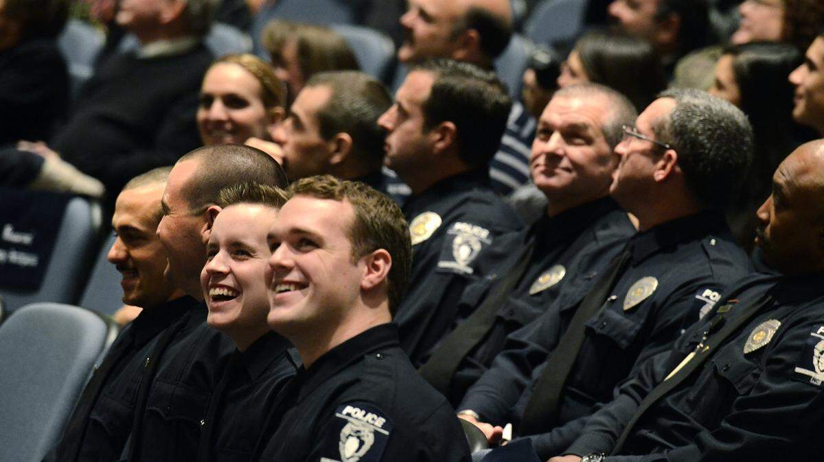 CMPD recruits laugh during a class video shown before the recruits were sworn in as officers on Jan. 17, 2014, at the auditorium in the Police Training Academy.