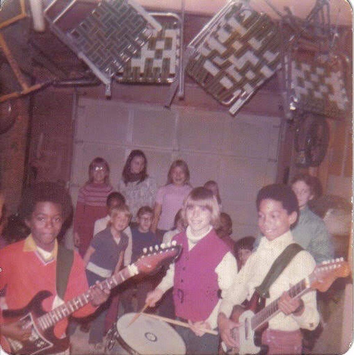 Gene Woods — at right, in the yellow shirt — plays in a garage with his first band. He’s holding the fake Fender Stratocaster his parents bought him.