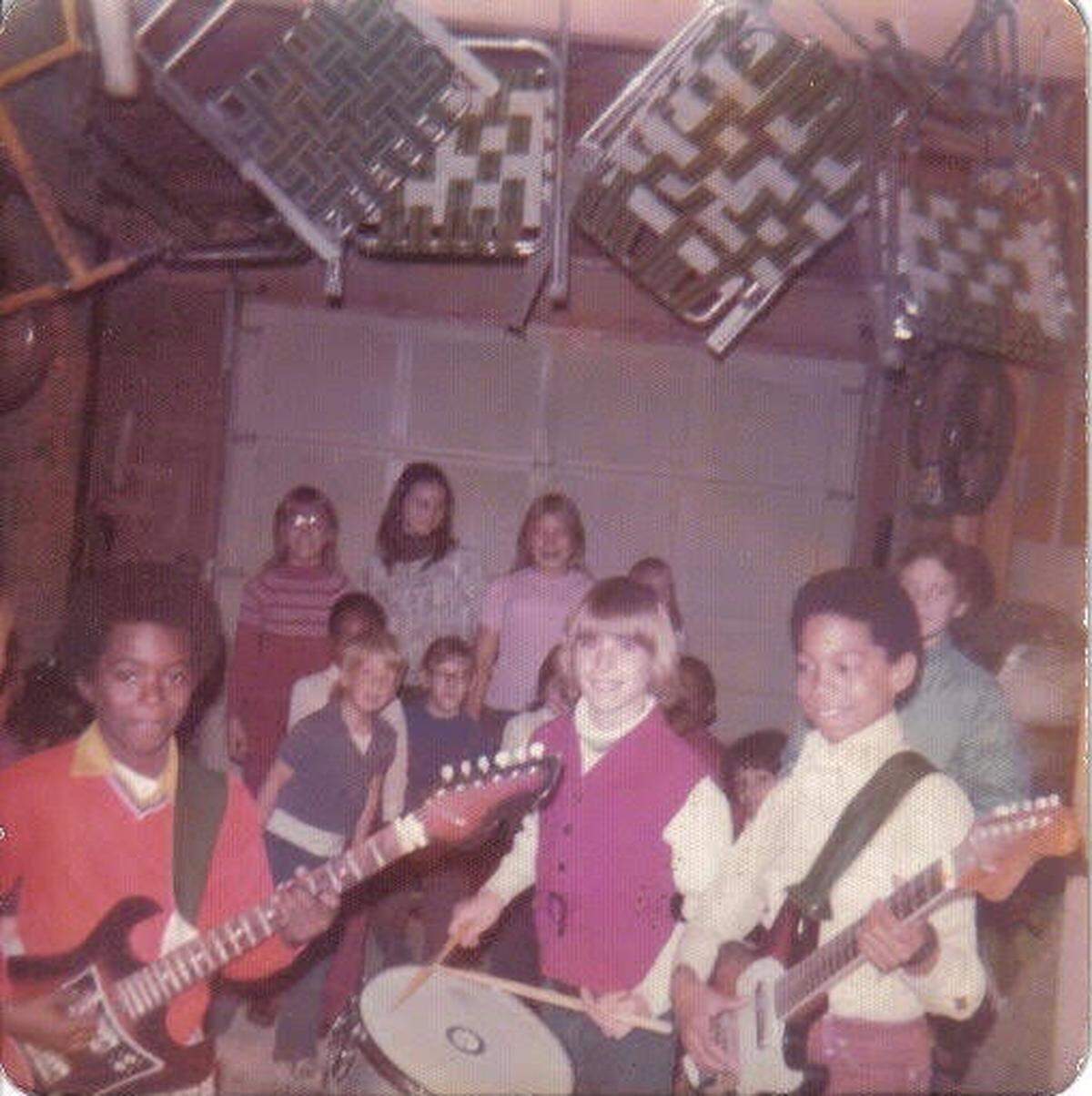 Gene Woods — at right, in the yellow shirt — plays in a garage with his first band. He’s holding the fake Fender Stratocaster his parents bought him.