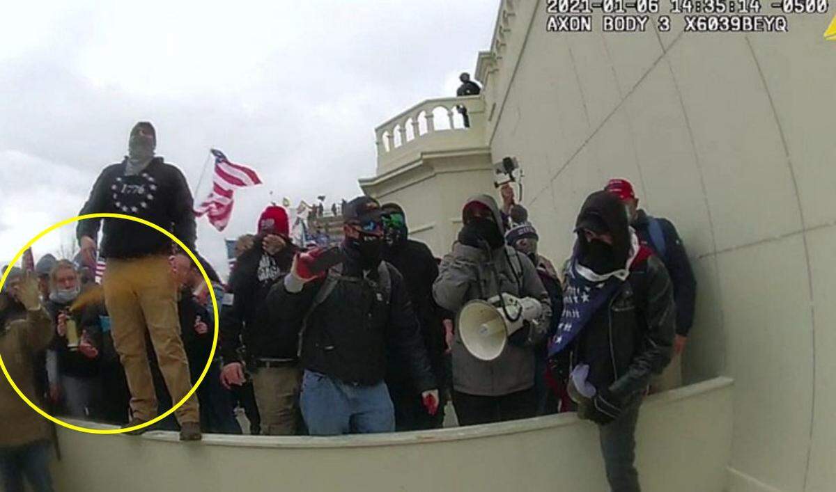 Aiden Bilyard of Cary aims a powerful chemical spray at police officers outside the U.S. Capitol on Jan. 6, 2021.