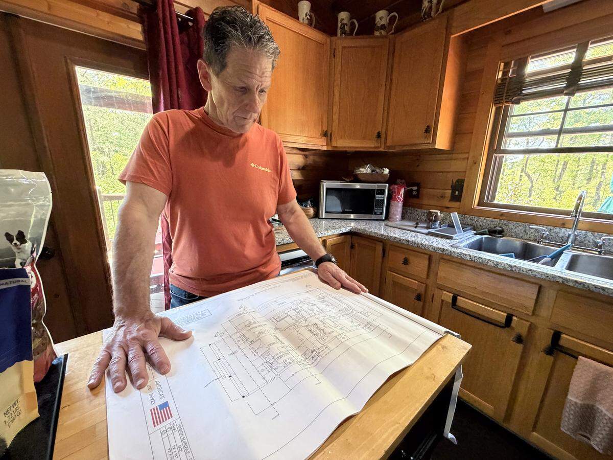 Ed Danyo looks over blueprints that would have been his log home in Millers Creek, N.C., on Wedsesday April 22, 2026.