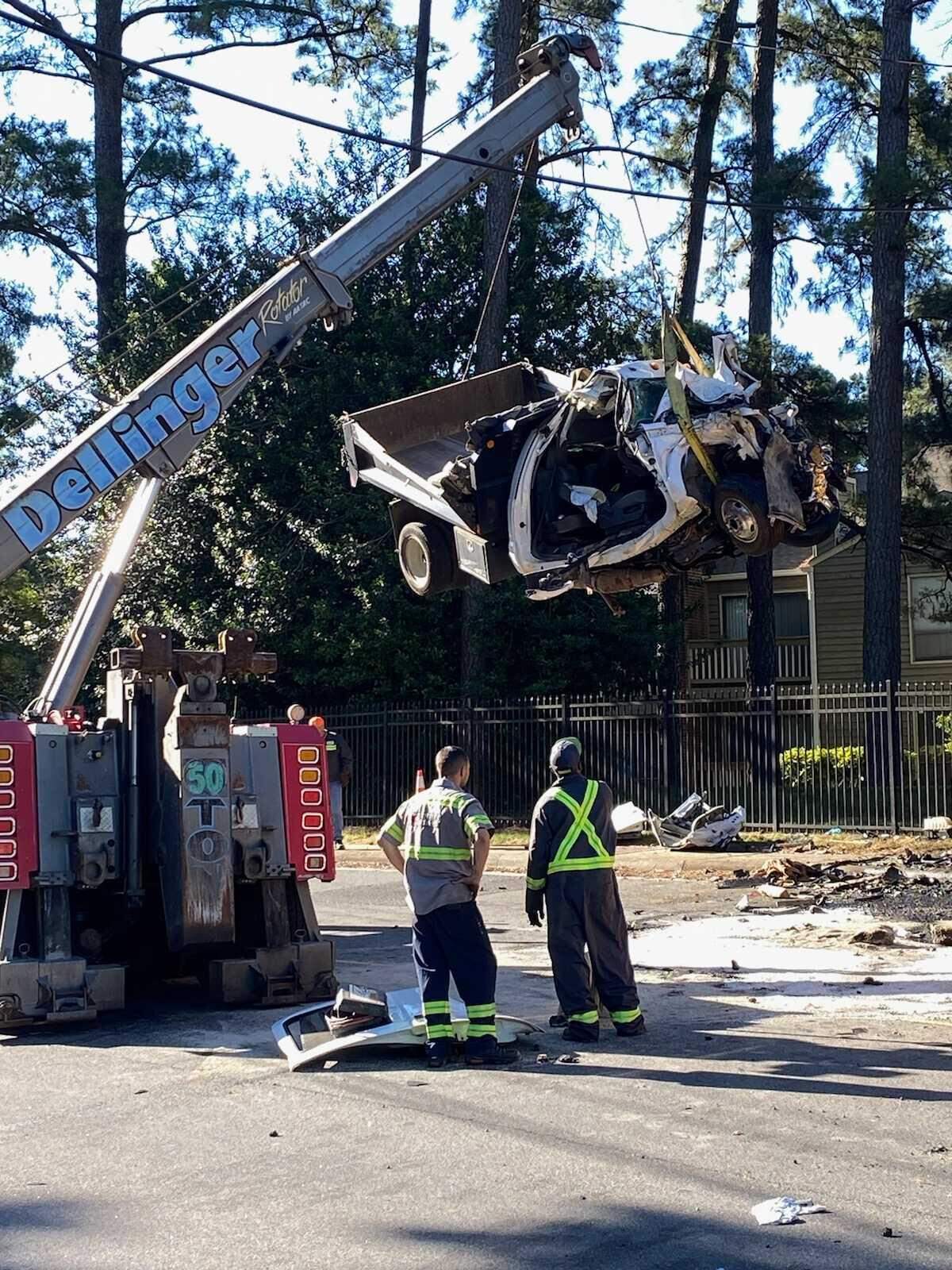 A crane lifts the wreckage of a dump truck that was involved in a crash with a Charlotte-Mecklenburg Schools bus and another vehicle at Sharonbrook Drive and Sharon Road West on Wednesday, May 11, 2022.