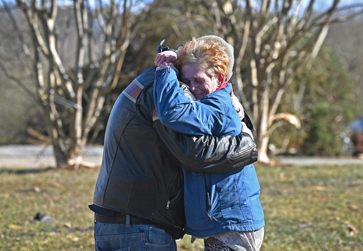 Richard Pack, left and Tammy Yates, right, console one another along Cindi Lane in Claremont, NC on Wednesday, January 10, 2024. Pack’s cousin Dustin Weaver was killed on Tuesday, January 9, 2024 when a tornado touched down in the area destroying the mobile home where he was living. Pack and Yates had been neighbors in the mobile home park for years.