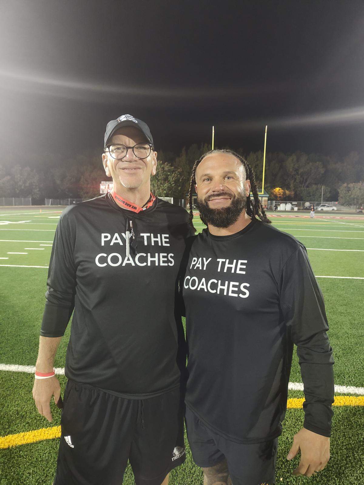 Butler’s Brian Hales (left) and West Charlotte’s Sam Greiner, co-hosts of The Charlotte Observer’s Talking Preps streaming show, were among a contigent of Charlotte football coaches to wear “Pay the coaches” t-shirts Friday to protest poor stipend pay