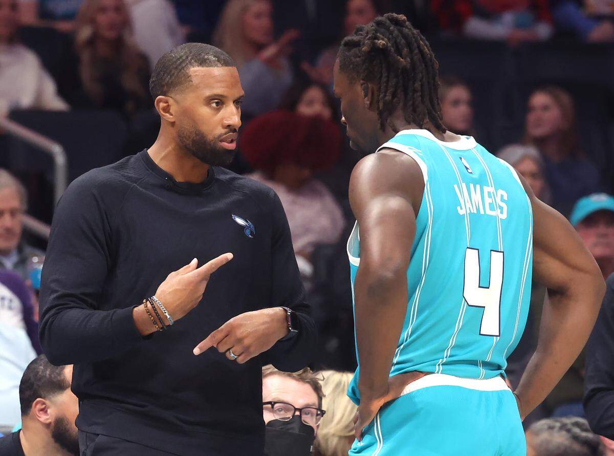 Charlotte Hornets head coach Charles Lee, left, speaks with guard Sion James during action against the Cleveland Cavaliers at Spectrum Center in Charlotte, North Carolina, on Wednesday, Jan. 21, 2026. 