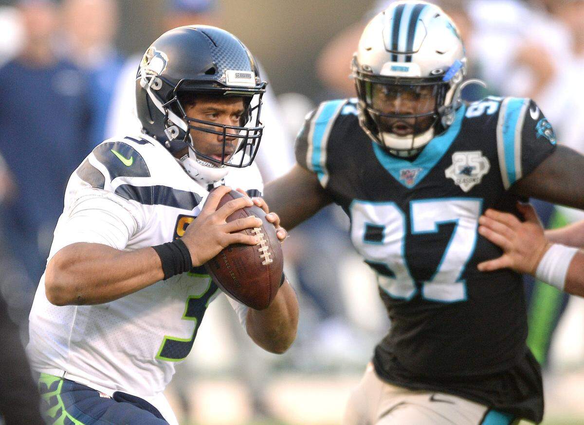 Seattle Seahawks quarterback Russell Wilson, left, scrambles out of the pocket looking for a receiver Sunday. Wilson completed 20 of 26 passes for 286 yards in the Seahawks’ 30-24 win.