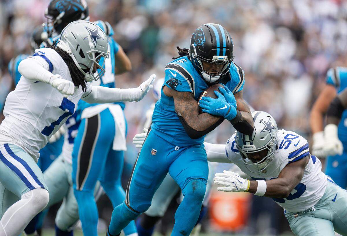 Carolina Panthers running back Rico Dowdle, center is tackled by Dallas Cowboys linebacker Shemar James on Sunday at Bank of America Stadium.