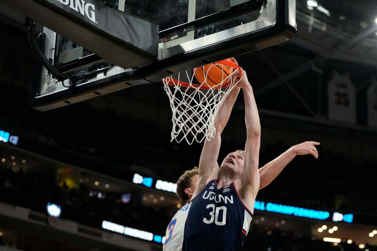 Connecticut Huskies forward Liam McNeeley (30) drives to the basket as Florida Gators center Micah Handlogten (3) defends during the second half in the second round of the 2025 NCAA Tournament at Lenovo Center in Raleigh.