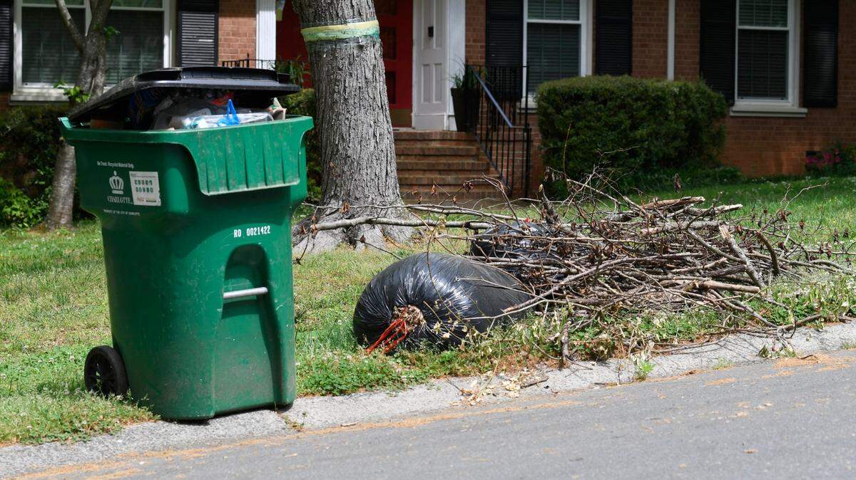 Yard waste is stacked beside a recycling bin during pickup day in Charlotte on Tuesday, April 7, 2020.Yes, yard waste pick up has been delayed but don’t put it in with your recyclables.
