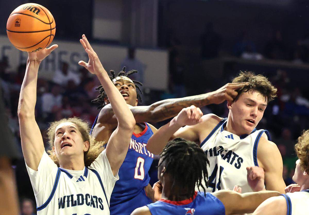 Lake Norman’s Santana Lynch, left, grabs control of a rebound as North Meck’s Isaiah Evans, center, attempts to knock the ball away during the AAAA Regional Championship on Thursday, March 14, 2024 at Lawrence Joel Veterans Memorial Coliseum in Winston-Salem, NC. North Meck defeated Lake Norman 65-61.