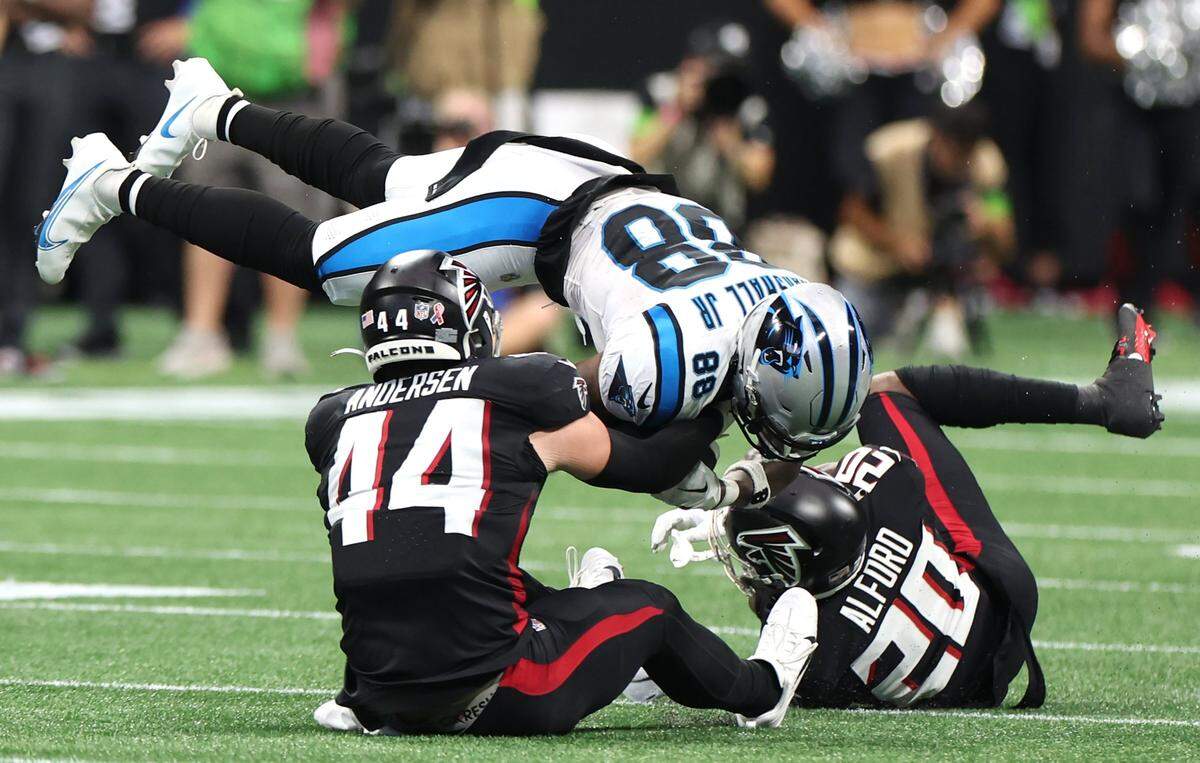 Carolina Panthers wide receiver Terrace Marshall secures the ball during a reception as Atlanta Falcons linebacker Troy Andersen, left and cornerback Dee Alford, right, make the tackle during first half action at Mercedes-Benz Stadium in Atlanta, GA on Sunday, September 10, 2023. The Falcons defeated the Panthers 24-10.
