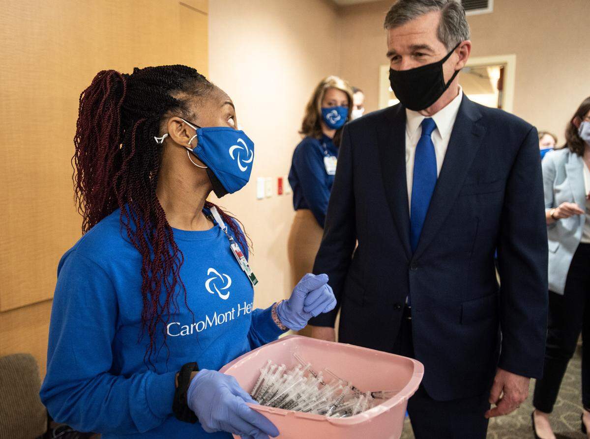 Gov. Roy Cooper (right) greets an employee at CaroMont Health in Gastonia, NC, on Wednesday, March 31, 2021.