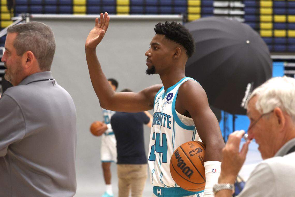 Charlotte Hornets Brandon Miller, center, motions to teammate Miles Bridges as he has his photograph taken during media day on Sept. 29.  