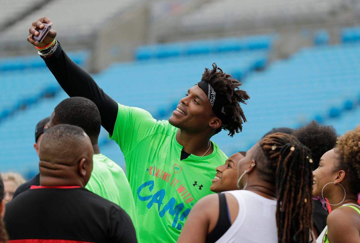 Carolina Panthers Cam Newton takes a selfie with fans during his charity kickball tournament in Charlotte, N.C., Friday, May 10, 2019. (AP Photo/Chuck Burton)